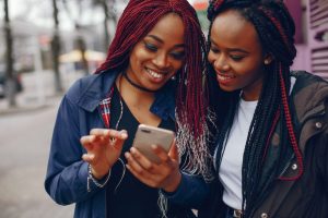 Two black women viewing a mobile device