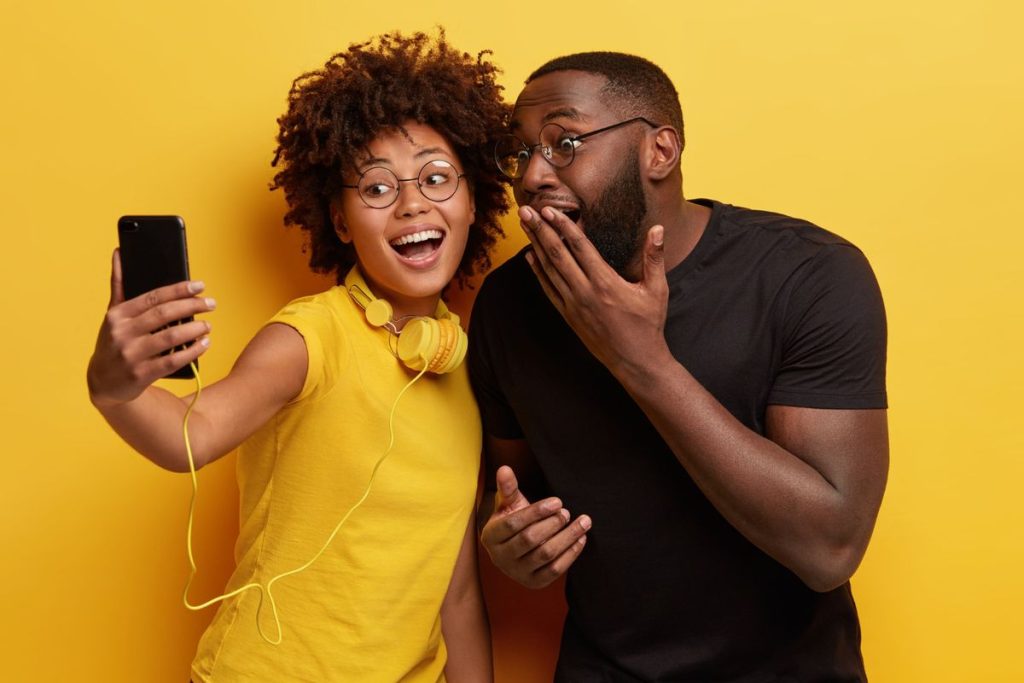2 black friends sharing a moment on smartphone